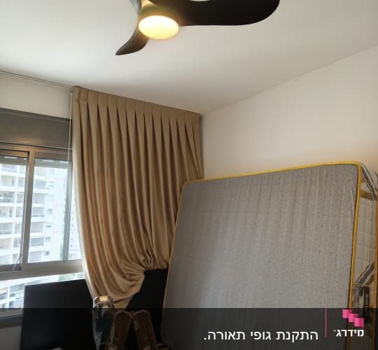 מאוורר תקרה מותקן בחדר עם מיטה וסולם